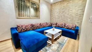 a blue couch in a living room with a table at A2 Luxe Moderne et Confort, 7 min du Stade Moulay Abdellah in Temara