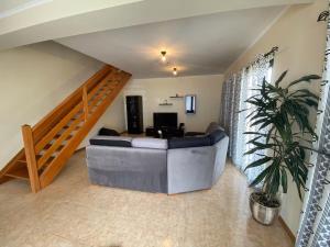 a living room with a couch and a staircase at Refugio do Falcão in Ponta Garça