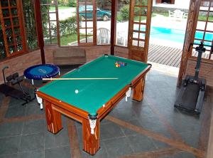 a pool table sitting inside of a room with a pool at Pousada do Encanto in Visconde De Maua