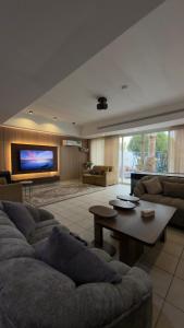 a living room with a couch and a table at فيلا بيتا خصوصيه في الشاطئ والمسبح in Durat Alarous