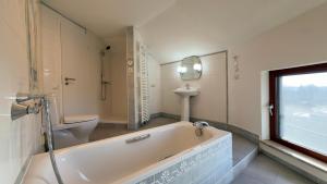 a bathroom with a tub and a toilet and a sink at Einzigartig übernachten im Wasserturm an der Elbe in Stelle +17 photos