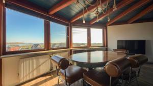 a dining room with a table and chairs and windows at Einzigartig übernachten im Wasserturm an der Elbe in Stelle