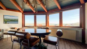 a room with a table and chairs and windows at Einzigartig übernachten im Wasserturm an der Elbe in Stelle