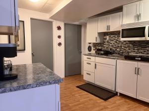 a kitchen with white cabinets and a brick wall at Gull lake in Winnipeg