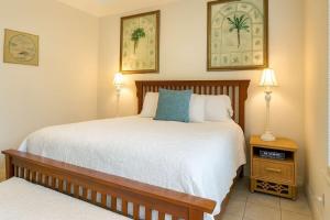 a bedroom with a large bed and two lamps at Beach & Palms condo condo in South Padre Island