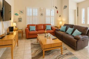 a living room with a couch and a table at Beach & Palms condo condo in South Padre Island