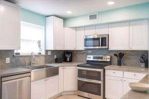 a kitchen with white cabinets and stainless steel appliances at Blizzard's Lighthouse home in Port Isabel