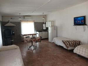 a room with a kitchen with a refrigerator and a table at Lodemabel in Bragado