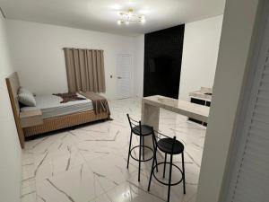 a bedroom with a bed and two black chairs at Hotel Luxx in Sinop +3 photos
