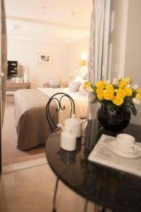 ロンドンにあるClaverley Court Apartments Knightsbridgeのベッドルーム1室(ベッド1台、黄色い花のテーブル付)