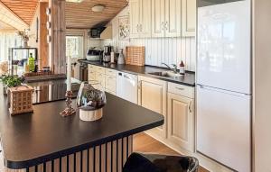 a kitchen with a white refrigerator and a black counter top at St Croix in Hadsund