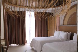 a hotel room with two beds and a window at Dahican Beach Resort and Spa in Sampong +3 photos