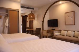 a hotel room with two beds and a couch at Dahican Beach Resort and Spa in Sampong