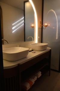 a bathroom with two sinks and a large mirror at Dahican Beach Resort and Spa in Sampong