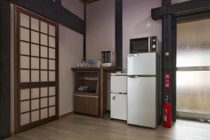 a kitchen with a refrigerator and a microwave on top of it at 甘口派room in Obanazawa
