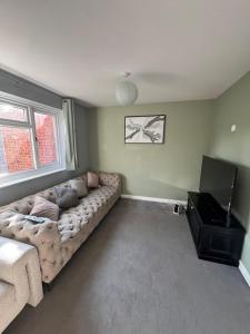 a living room with a couch and a television at Cosy Home Contractors, Relocations, Coffee Machine in Beoley