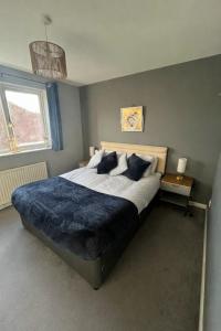 a bedroom with a large bed with a blue blanket at Cosy Home Contractors, Relocations, Coffee Machine in Beoley