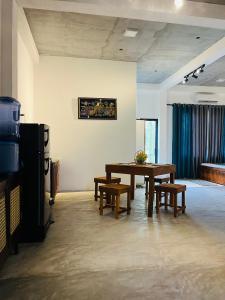 a living room with a table and benches and a couch at Pixie Haven Lodge Hiriketiya in Dickwella