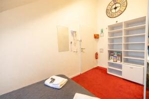 a room with a bed and a clock on the wall at DATRI Petite Suite 4 in Vienna
