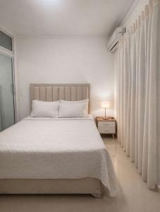a bedroom with a white bed and a window at EL ricon del paseo in Mendoza