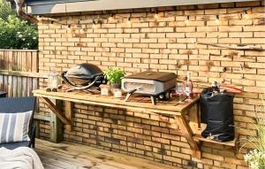 a brick wall with a table with a grill on it at Awesome Home In Thyborøn With Wifi in Thyborøn