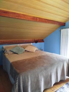 a bed in a bedroom with a wooden ceiling at Chalé Studio Haven, microcasa com Mezanino e banheira in Lumiar