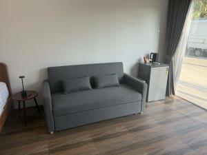 a couch with two pillows in a living room at Roomz at Rawai in Ban Saiyuan (1)