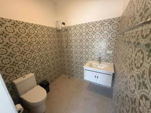 a bathroom with a toilet and a sink at Roomz at Rawai in Ban Saiyuan (1)