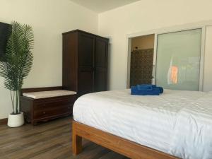 a bedroom with a large bed and a plant at Roomz at Rawai in Ban Saiyuan (1)
