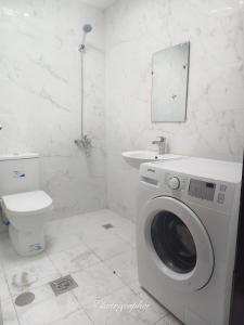 a bathroom with a washing machine and a toilet at studio in Abu Dhabi