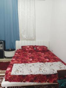 a bedroom with a bed with red and white sheets at studio in Abu Dhabi