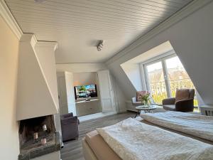 a large bedroom with two beds and a fireplace at Ferienwohnung-Weidenstieg-OG in Wenningstedt