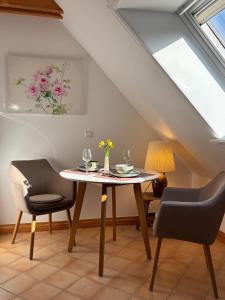 a dining room with a table and two chairs at Ferienwohnung-Weidenstieg-OG in Wenningstedt