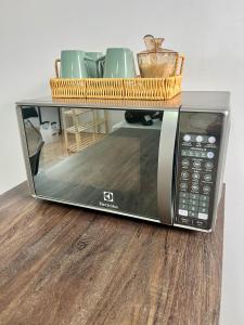 a microwave with a basket on top of it at Loft 967 in Itajaí