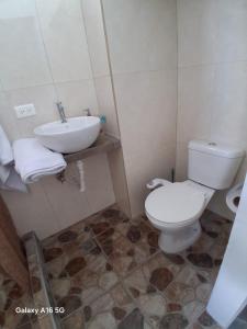 a bathroom with a toilet and a sink at Pescadito in Puerto Ayora +5 photos