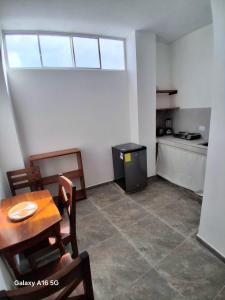 a dining room with a table and a kitchen at Pescadito in Puerto Ayora