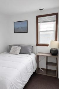 a white bedroom with a bed and a window at Location! Location! 2bd 1bth spacious apartment! in Chicago