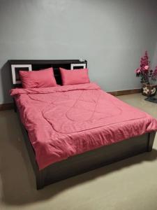 a large bed with pink sheets and pink pillows at Crowd free own pace and space in Rayong in Ban Chak Khamin