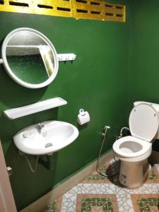a green bathroom with a sink and a mirror at Crowd free own pace and space in Rayong in Ban Chak Khamin