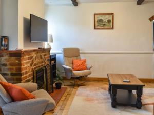 a living room with two chairs and a fireplace at Why Not in Canterbury