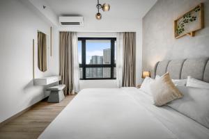 a bedroom with a large white bed with a window at Cavera Bukit Bintang in Kuala Lumpur +51 photos