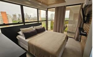 a bedroom with a large bed with a large window at Reserva Madero Loft in Natal +8 photos