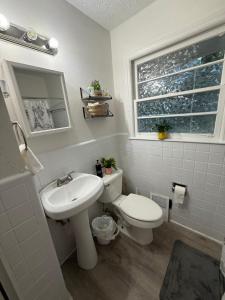 a bathroom with a sink and a toilet and a window at Crema queen in Decatur