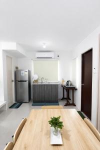 eine Küche mit einem Holztisch und einem Kühlschrank in der Unterkunft Ben & Ben in San Fernando