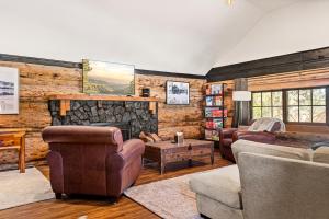 a living room with couches and a stone fireplace at The Hideaway Big Bear in Big Bear Lake