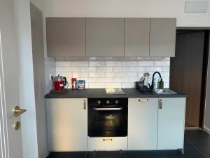 a kitchen with white cabinets and a black oven at Armonia Old Town in Poznań +16 photos