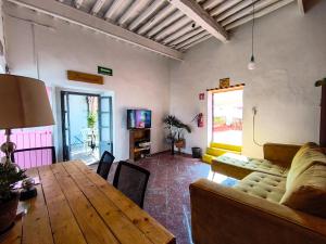 a living room with a wooden table and a couch at Sukha Hostel San Luis in San Luis Potosí