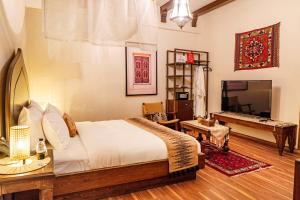 a bedroom with a bed and a table and a television at بوتيك خان عطره in Medina