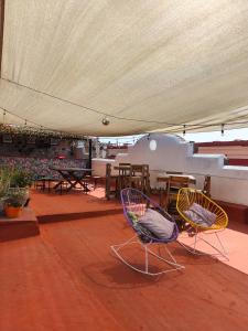 two chairs under a tent with tables and tables at Sukha Hostel San Luis in San Luis Potosí