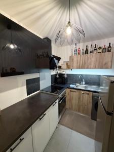 a kitchen with white cabinets and black counter tops at Grand Studio Neuf in Ajaccio